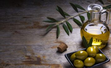 tasty looking olives extra virgin olive oil olive leafs dark wooden background